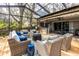 Enclosed patio with wicker furniture, wood flooring, and partial covering providing an inviting outdoor relaxation space at 1857 Castle Woods Dr, Clearwater, FL 33759