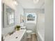 Bathroom featuring gray cabinets, shower and tub, light blue walls, and a bright window at 2320 E Harbor S Dr, St Petersburg, FL 33705