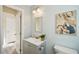 Bathroom featuring gray cabinets, toilet, light blue walls, and a bright window at 2320 E Harbor S Dr, St Petersburg, FL 33705