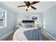 Bright bedroom with light blue walls, a ceiling fan, and large windows for natural light at 2320 E Harbor S Dr, St Petersburg, FL 33705