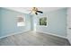 Bright bedroom with two windows, ceiling fan, and light wood-look flooring at 2320 E Harbor S Dr, St Petersburg, FL 33705