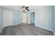 Large bedroom with updated ceiling fan, gray wood-look flooring, and dual closets at 2320 E Harbor S Dr, St Petersburg, FL 33705