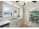 Kitchen featuring gray cabinets, stainless steel appliances, and a view into the bright dining room at 2320 E Harbor S Dr, St Petersburg, FL 33705