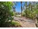 A backyard pathway leads to a serene lake view through mature trees and lush greenery at 2823 Clubhouse Dr, Plant City, FL 33566