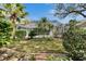 Landscaped backyard featuring a screened-in pool area and lush greenery, creating a private outdoor retreat at 2823 Clubhouse Dr, Plant City, FL 33566