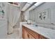 Bright bathroom with a skylight, white tile floor, wood cabinets, and decorative accents at 2823 Clubhouse Dr, Plant City, FL 33566
