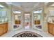 Bright bathroom featuring dual vanities, a black rug, and mirrored closet doors at 2823 Clubhouse Dr, Plant City, FL 33566