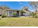 Charming single-story home with a well-manicured lawn, landscaped garden, and a gray exterior at 2823 Clubhouse Dr, Plant City, FL 33566