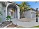 Close up of home's front entrance with stone garden, palm tree, and large arched doorway at 2823 Clubhouse Dr, Plant City, FL 33566