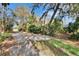 A landscaped driveway lined with mature trees and vegetation, showcasing the property's natural beauty at 2823 Clubhouse Dr, Plant City, FL 33566