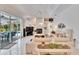 Open living area with a view of the pool, white tile floors, and a cozy fireplace at 2823 Clubhouse Dr, Plant City, FL 33566