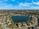 An aerial view showcases a community with houses, ponds, and streets under a blue sky at 28565 Picana Ln, Wesley Chapel, FL 33543