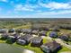 Wide aerial view showcasing the community's well-manicured lawns and proximity to the lake at 28565 Picana Ln, Wesley Chapel, FL 33543