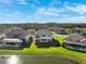 Expansive aerial view of a neighborhood showcasing well-maintained homes with lush green lawns near a tranquil lake at 28565 Picana Ln, Wesley Chapel, FL 33543