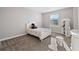 Cozy bedroom with neutral walls, plush carpet, a sunny window and a bookshelf at 28565 Picana Ln, Wesley Chapel, FL 33543