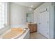 Bright bathroom featuring a soaking tub, glass block window, and wood cabinets at 3017 Minuteman Ln, Brandon, FL 33511