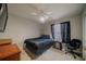 This cozy bedroom features a ceiling fan, a dark black bedspread, a window, and a work station with office chair at 3017 Minuteman Ln, Brandon, FL 33511