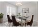 Elegant dining room with a glass-top table, chandelier, seating for six, and decorative artwork at 3017 Minuteman Ln, Brandon, FL 33511