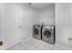 Convenient laundry room featuring a modern washer and dryer, along with tile flooring and white walls at 3017 Minuteman Ln, Brandon, FL 33511