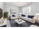 Bright living room featuring white furniture, plantation shutters, and stylish decor with blue accents and a clear coffee table at 3017 Minuteman Ln, Brandon, FL 33511