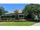 Street view of community sign surrounded by lush landscaping, flowers, and greenery under a sunny sky at 3017 Minuteman Ln, Brandon, FL 33511