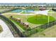 Aerial view of a well-equipped playground with swings, train, tennis court, and climbing structure at 31381 Amberview Bend, Wesley Chapel, FL 33545