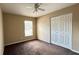 Neutral bedroom with a ceiling fan, a large window, and a closet with double doors at 3211 E 23Rd Ave, Tampa, FL 33605