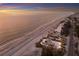 Breathtaking aerial shot captures the expansive beach, adjacent road, and stunning ocean view at sunset at 3341 Gulf Of Mexico Dr, Longboat Key, FL 34228