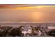 Aerial view of beachfront home with palm trees, driveways, and the ocean at sunset at 3341 Gulf Of Mexico Dr, Longboat Key, FL 34228