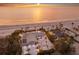 Aerial view of a beachfront property with a house, guest house, mature trees, and a private beach at 3341 Gulf Of Mexico Dr, Longboat Key, FL 34228