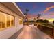 Backyard deck with lots of room for entertaining overlooking palm trees and colorful sky at 3341 Gulf Of Mexico Dr, Longboat Key, FL 34228
