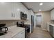 Modern kitchen featuring white cabinets, stainless steel appliances, and quartz countertops at 3341 Gulf Of Mexico Dr, Longboat Key, FL 34228
