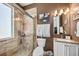 Bathroom featuring glass shower door, stone tile shower, vanity with sink and art at 4301 W San Luis St, Tampa, FL 33629