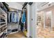 Bathroom and Walk-in Closet featuring a stone tiled shower and floors, and custom shelving for ample storage space at 4301 W San Luis St, Tampa, FL 33629