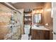 Bathroom featuring glass shower door, stone tile shower and vanity with sink at 4301 W San Luis St, Tampa, FL 33629