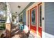 Inviting front porch with decorative seating and a red front door with sidelights at 4301 W San Luis St, Tampa, FL 33629