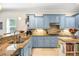 Charming kitchen with blue cabinets, granite counters, stainless sink, and a stylish island with butcher block top at 4301 W San Luis St, Tampa, FL 33629