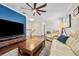 Well-lit living room with ceiling fan, hardwood floors, cream couch, and blue accent wall at 4301 W San Luis St, Tampa, FL 33629