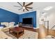 Living room features blue accent wall, hardwood floors, ceiling fan and leather couch at 4301 W San Luis St, Tampa, FL 33629