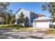 Two-story home showing a side view of the garage, well-maintained lawn, and mature trees at 4301 W San Luis St, Tampa, FL 33629