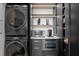Modern laundry closet featuring a black stackable washer and dryer with built in storage and shelving at 449 S 12Th St # 2702, Tampa, FL 33602