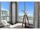 Bright living room with a large picture window, white chaise lounge, telescope, and views of the city and bay at 449 S 12Th St # 2702, Tampa, FL 33602