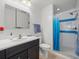 Fresh bathroom with a large mirror, walk-in shower, and blue decorative tile at 470 Hibiscus N Ln, Dunedin, FL 34698