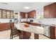 Modern kitchen with stainless steel appliances, dark wood cabinets and a large island with seating at 470 Hibiscus N Ln, Dunedin, FL 34698