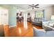 Bright living room features hardwood floors, neutral walls, ceiling fan, and is open to dining and kitchen at 470 Hibiscus N Ln, Dunedin, FL 34698