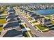 Expansive aerial view of a neighborhood featuring well-maintained homes and a scenic lake, creating a serene community atmosphere at 5456 Logan Cave Ave, Wimauma, FL 33598