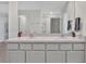 Bright bathroom featuring a double sink vanity with white cabinets and neutral countertops, complemented by modern fixtures at 5456 Logan Cave Ave, Wimauma, FL 33598