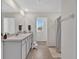 Clean bathroom with a double vanity, a shower with curtains, and neutral tiling at 5456 Logan Cave Ave, Wimauma, FL 33598
