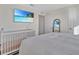 Cozy bedroom featuring a crib, a large bed, and a TV, creating a comfortable and relaxing atmosphere at 5456 Logan Cave Ave, Wimauma, FL 33598