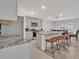 Open-concept kitchen with stainless steel appliances, a granite island, and barstool seating at 5456 Logan Cave Ave, Wimauma, FL 33598